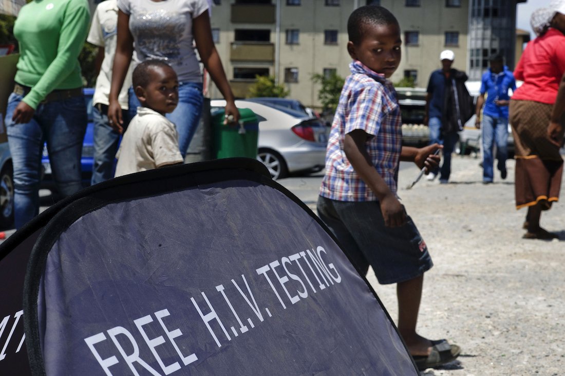 Children walk past a US funded mobile AIDS testing unit in Cape Town